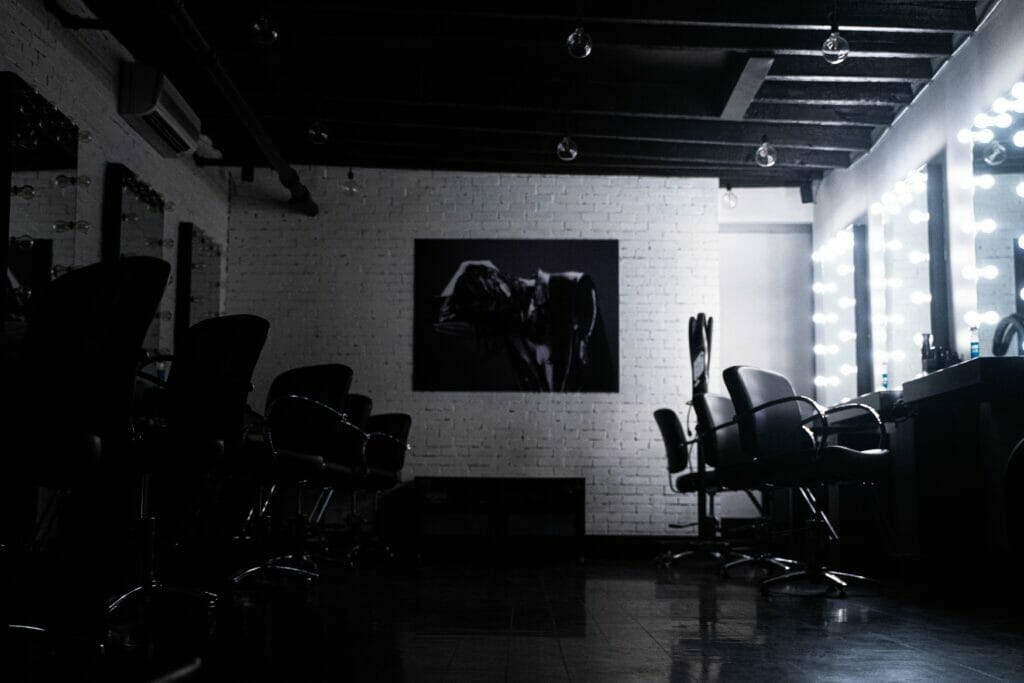 A dark hair salon equipped with chairs and ambient lighting to create your personalized lookbook.