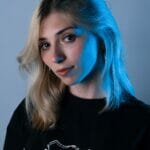A blonde woman wearing a black t - shirt.