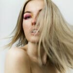 A blond woman with her hair blowing in the wind.
