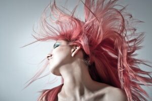 A woman with pink hair flying in the air.