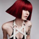 A woman with a red bob posing for a photo.