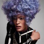A woman in a black leather outfit with a purple wig.