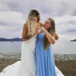 One bride with siren hair extensions posing for a picture on a beach.